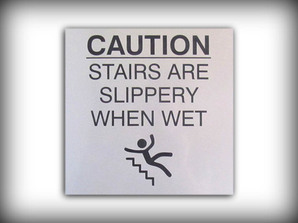 Engraved sign with graphic, caution, stairs are slippery when wet