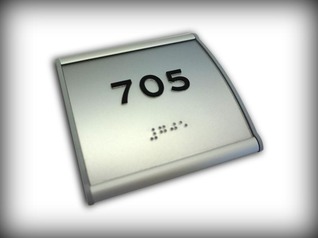 Custom engraved Braille & Tactile ADA / AODA room numbering sign in convex holder